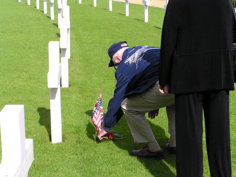 Gene Goodrick placing sprig and poppy at another 384th grave.JPG