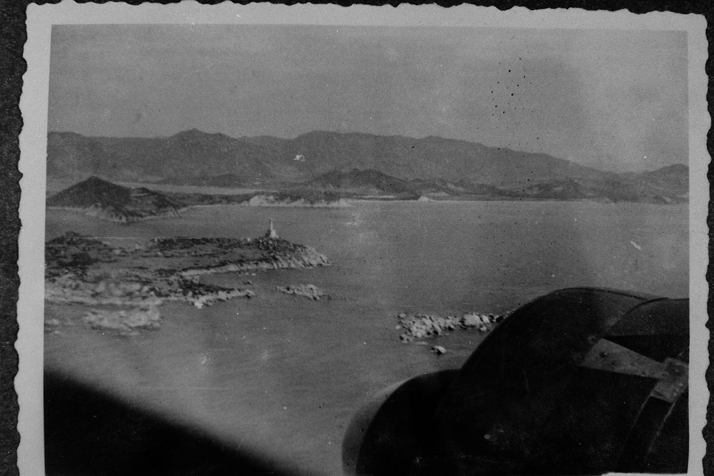 Flying over mountainous coast, islands, and lighthouse