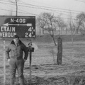 Man with pipe in front of sign