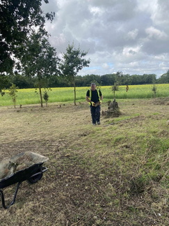 Shaun Wilson digs out the rocks so we can strim and mow